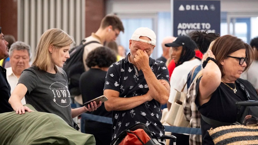 Pasajeros intentan cambiar su vuelo en el Aeropuerto Internacional Hartsfield-Jackson de Atlanta el viernes. (Ben Gray/AP)