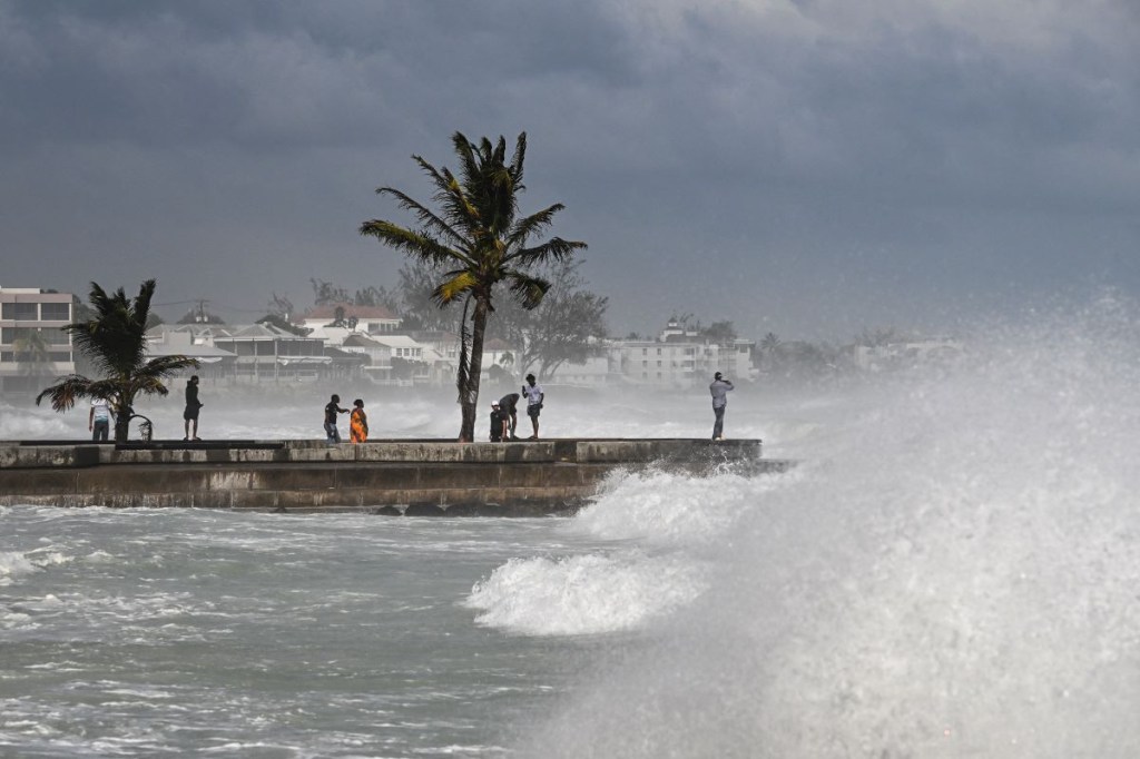 La gente visita un muelle durante la marea alta después del paso del huracán Beryl en Oistins, cerca de Bridgetown, Barbados, el 1 de julio de 2024. (Foto de CHANDAN KHANNA/AFP vía Getty Images)