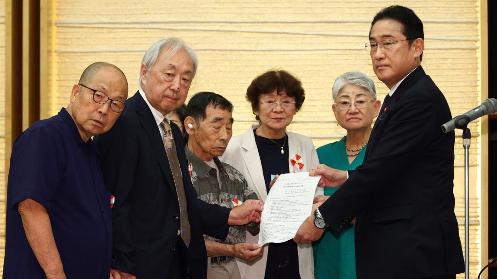 El primer ministro de Japón, Fumio Kishida, se reúne con los demandantes de un juicio por esterilización forzosa, que entregaron una carta de demandas en su oficina de Tokio el 17 de julio de 2024. (JIJI Press/AFP/Getty Images)