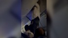 Video muestra a pasajero de avión bajar del compartimento superior para equipaje después de una fuerte turbulencia