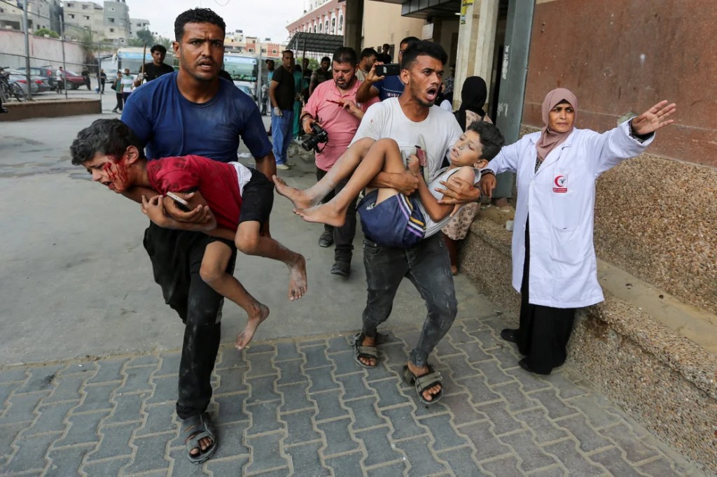 Los palestinos cargan a niños heridos por un ataque israelí, en el hospital Nasser, el 22 de julio. Las personas desplazadas en Khan Younis expresaron su enojo contra Israel, Hamas y otros líderes árabes por la guerra. (Hatem Khaled/Reuters)