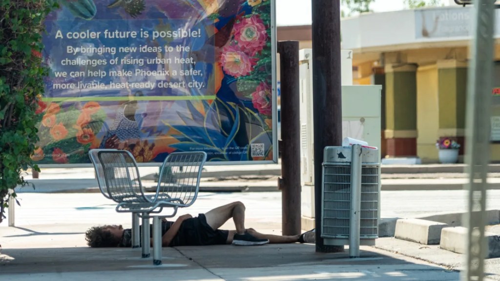 Un hombre sin vivienda encuentra poco respiro del calor a la sombra de una parada de autobús en Phoenix. Julian Quinones/CNN