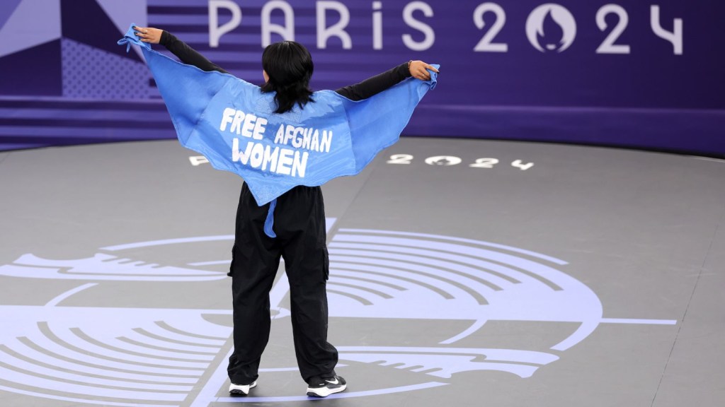 La B-girl Talash, del equipo olímpico de refugiados, compite con una capa que dice "liberen a las mujeres afganas libres" durante la preclasificatoria de B-girls el viernes. (Ezra Shaw/Getty Images)