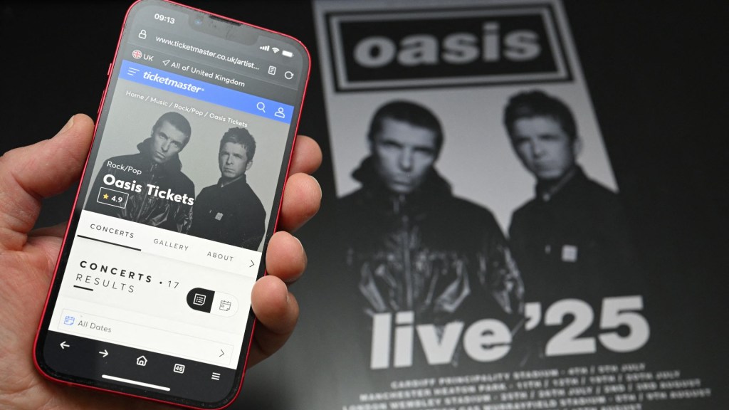 Un fan usa un teléfono para acceder a un sitio web de venta de entradas en línea para comprar boletos para la gira "Live '25" de Oasis el 31 de agosto de 2024. Crédito: Foto de OLI SCARFF/AFP vía Getty Images