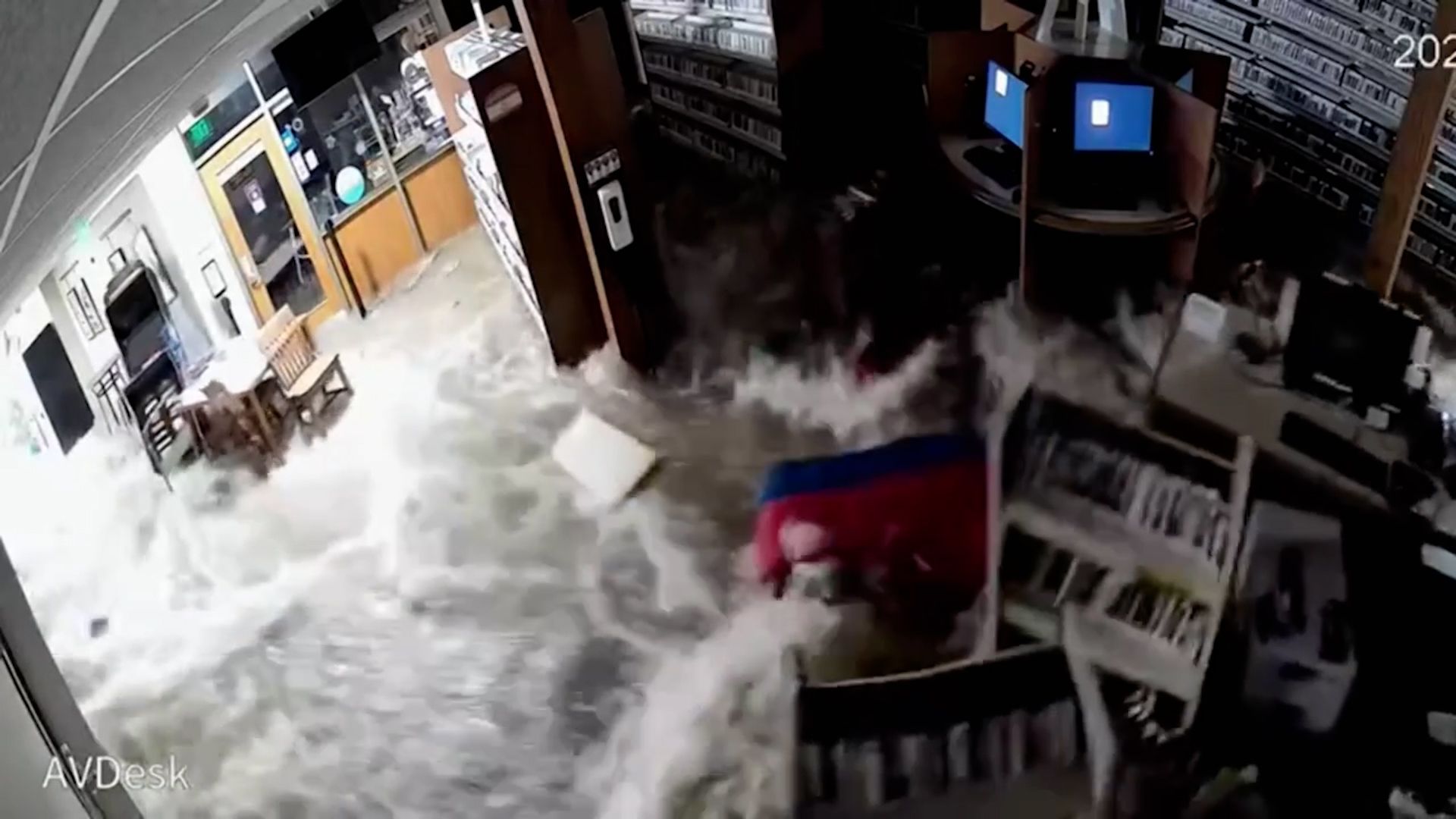 Una ola de agua atraviesa la pared de la biblioteca y llena el edificio  como una bañera