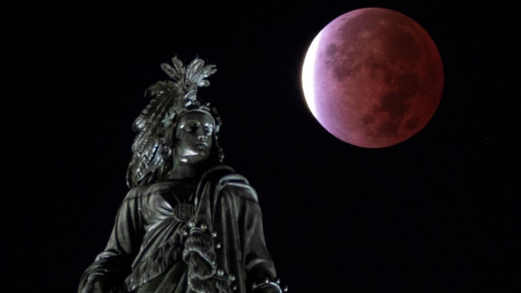 Un eclipse lunar parcial se observa detrás de la Estatua de la Libertad, en Capitol Hill, en la ciudad de Washington, a primera hora del 19 de noviembre de 2021. (Foto: ANDREW CABALLERO-REYNOLDS/AFP vía Getty Images)