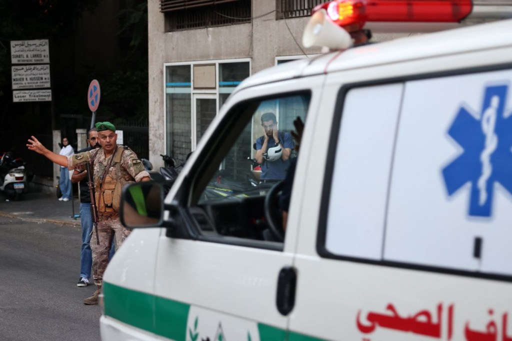 Un soldado del ejército libanés hace un gesto hacia una ambulancia que lleva a los heridos a un hospital en Beirut el 17 de septiembre de 2024,. (Foto de ANWAR AMRO/AFP vía Getty Images)