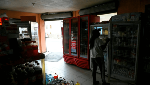 Una mujer se encuentra dentro de una tienda oscura debido al racionamiento de energía en Quito, el 18 de abril de 2024. (Foto de RODRIGO BUENDIA/AFP vía Getty Images)