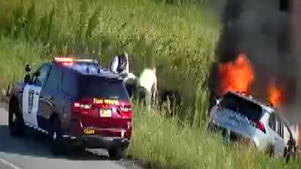 Un policía y otros conductores lograr sacar a una persona de un auto en llamas