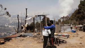 Una pareja se abraza mientras se eleva humo de un incendio forestal en una colina en Quito el 25 de septiembre de 2024. (Foto: GALO PAGUAY/AFP vía Getty Images)