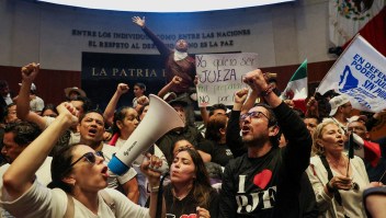 Los manifestantes levantan los puños después de ingresar al edificio del Senado el martes 10 de septiembre de 2024. (Luis Cortés/Reuters)