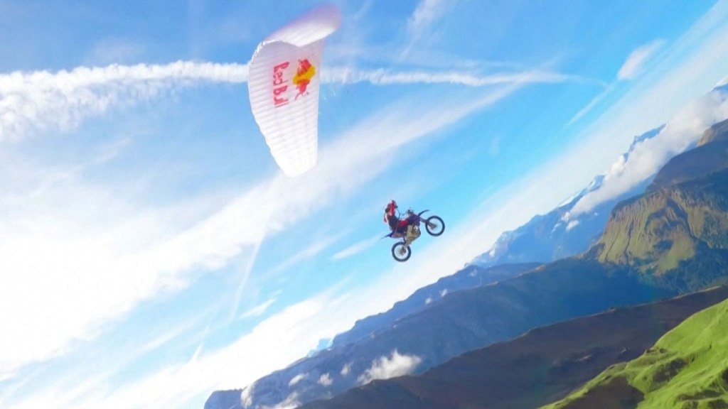 Piloto de motocross realiza una arriesgada maniobra volando en parapente