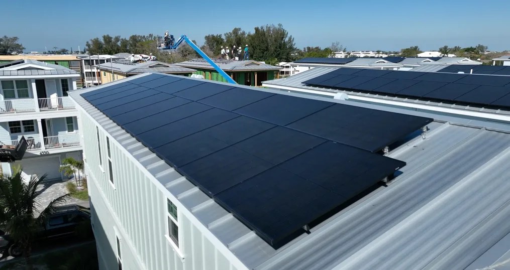 Trabajadores fijando paneles solares a las juntas verticales elevadas de los tejados para evitar que salgan volando durante las violentas tormentas de abril de 2024. (Julian Quinones/CNN/Archivo)