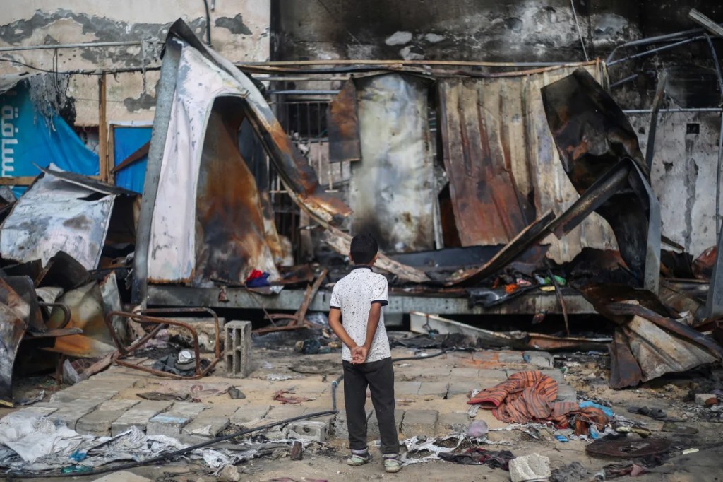 Un niño palestino observa los refugios destruidos en el lugar de un ataque aéreo israelí que alcanzó tiendas de campaña para personas desplazadas dos días antes en el patio del Hospital de los Mártires de Al-Aqsa en Deir al-Balah, en el centro de Gaza, el 16 de octubre de 2024. (Eyad Baba/AFP/Getty Images)