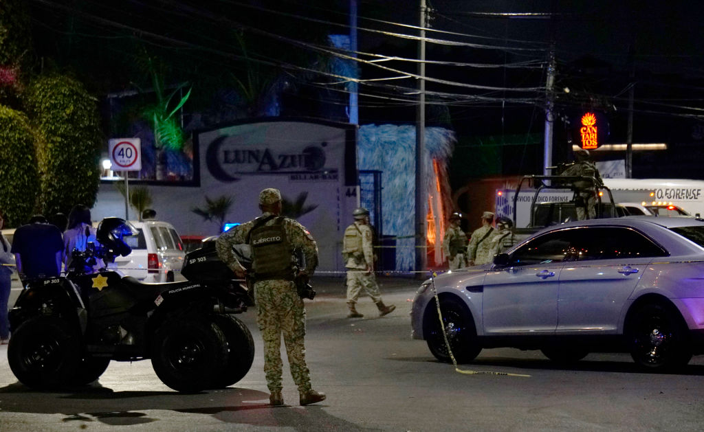 Soldados del Ejército mexicano y agentes de seguridad pública montan guardia afuera del bar Los Cantaritos donde un grupo armado irrumpió en la noche de sábado, matando a diez personas y dejando al menos siete más heridas, en la ciudad de Querétaro, estado de Querétaro, México, el 10 de noviembre de 2024. MARIO ARMAS/AFP vía Getty Images